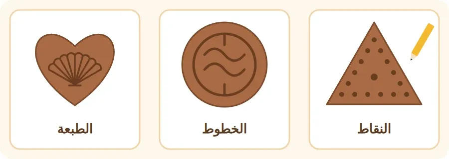 ثلاثة أشكال من الطين مزيّنة: مثلث بالنقاط، ودائرة بالخطوط، وقلب بطبعة صدفة